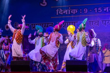 Puşkar, Rajasthan, Hindistan - 11 Kasım 2024: Bhangra, Bhangra Sanatçılar Grubu, renkli etnik elbiseler içinde dans ediyorlar..