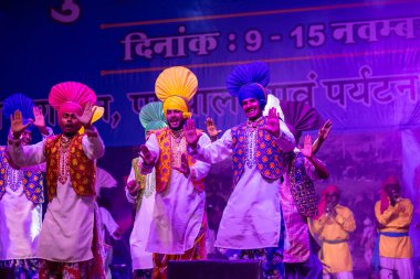 Puşkar, Rajasthan, Hindistan - 11 Kasım 2024: Bhangra, Bhangra Sanatçılar Grubu, renkli etnik elbiseler içinde dans ediyorlar..