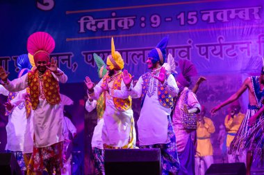 Puşkar, Rajasthan, Hindistan - 11 Kasım 2024: Bhangra, Bhangra Sanatçılar Grubu, renkli etnik elbiseler içinde dans ediyorlar..