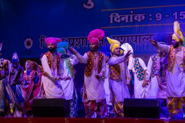 Puşkar, Rajasthan, Hindistan - 11 Kasım 2024: Bhangra, Bhangra Sanatçılar Grubu, renkli etnik elbiseler içinde dans ediyorlar..