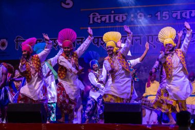 Puşkar, Rajasthan, Hindistan - 11 Kasım 2024: Bhangra, Bhangra Sanatçılar Grubu, renkli etnik elbiseler içinde dans ediyorlar..