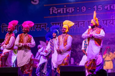Puşkar, Rajasthan, Hindistan - 11 Kasım 2024: Bhangra, Bhangra Sanatçılar Grubu, renkli etnik elbiseler içinde dans ediyorlar..