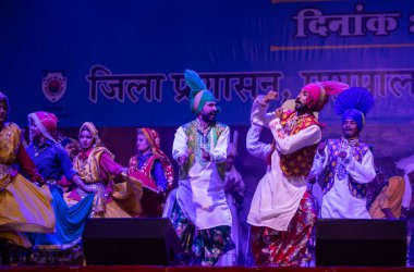 Puşkar, Rajasthan, Hindistan - 11 Kasım 2024: Bhangra, Bhangra Sanatçılar Grubu, renkli etnik elbiseler içinde dans ediyorlar..