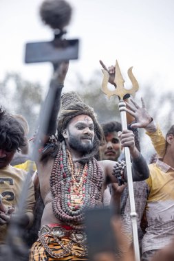 Varanasi, Uttar Pradesh, Hindistan - 20 Mart 2024: Masan Holi, Harishchandra ghat 'ta düzenlenen kutlama sırasında efendi shiva gibi giyinmiş kuru külle boyanmış bir erkek dindar portresi.