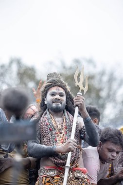 Varanasi, Uttar Pradesh, Hindistan - 20 Mart 2024: Masan Holi, Harishchandra ghat 'ta düzenlenen kutlama sırasında efendi shiva gibi giyinmiş kuru külle boyanmış bir erkek dindar portresi.