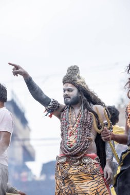 Varanasi, Uttar Pradesh, Hindistan - 20 Mart 2024: Masan Holi, Harishchandra ghat 'ta düzenlenen kutlama sırasında efendi shiva gibi giyinmiş kuru külle boyanmış bir erkek dindar portresi.
