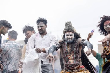 Varanasi, Uttar Pradesh, Hindistan - 20 Mart 2024: Masan Holi, Harishchandra ghat 'ta düzenlenen kutlama sırasında efendi shiva gibi giyinmiş kuru külle boyanmış bir erkek dindar portresi.