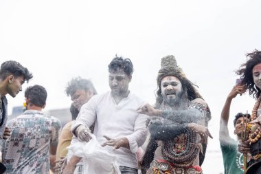 Varanasi, Uttar Pradesh, Hindistan - 20 Mart 2024: Masan Holi, Harishchandra ghat 'ta düzenlenen kutlama sırasında efendi shiva gibi giyinmiş kuru külle boyanmış bir erkek dindar portresi.