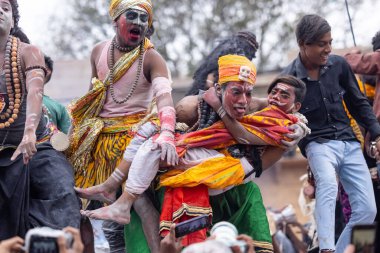 Varanasi, Uttar Pradesh, Hindistan - 20 Mart 2024: Masan Holi, Harishchandra ghat 'ta düzenlenen kutlama sırasında efendi shiva gibi giyinmiş kuru külle boyanmış bir erkek dindar portresi.
