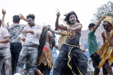 Varanasi, Uttar Pradesh, Hindistan - 20 Mart 2024: Masan Holi, Harishchandra ghat 'ta düzenlenen kutlama sırasında efendi shiva gibi giyinmiş kuru külle boyanmış bir erkek dindar portresi.