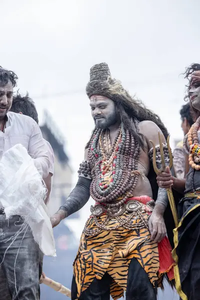 Varanasi, Uttar Pradesh, Hindistan - 20 Mart 2024: Masan Holi, Harishchandra ghat 'ta düzenlenen kutlama sırasında efendi shiva gibi giyinmiş kuru külle boyanmış bir erkek dindar portresi.