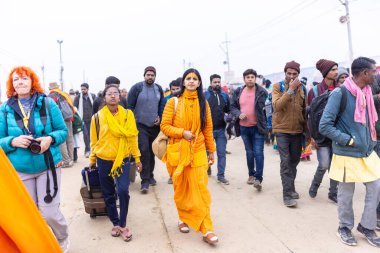 Prayagraj, Uttar Pradesh, Hindistan - 14 Ocak 2025: Mahakumbh, the group of holy women adotee walking on kumbh mela at å agraj post took the amrit snaan at sangam on makar sankranti.