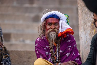Varanasi, Uttar Pradesh, Hindistan - 20 Ocak 2024: Varanasi 'deki çetelerin yakınındaki ghatlarda oturan geleneksel bir sadhu baba resmi. Sadhu, Kaşhi 'de Ganga yakınlarında ayinler düzenler..