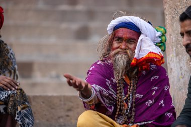 Varanasi, Uttar Pradesh, Hindistan - 20 Ocak 2024: Varanasi 'deki çetelerin yakınındaki ghatlarda oturan geleneksel bir sadhu baba resmi. Sadhu, Kaşhi 'de Ganga yakınlarında ayinler düzenler..