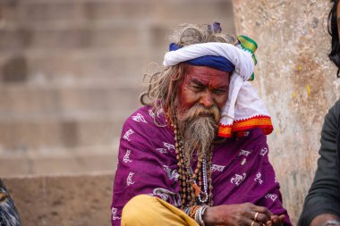 Varanasi, Uttar Pradesh, Hindistan - 20 Ocak 2024: Varanasi 'deki çetelerin yakınındaki ghatlarda oturan geleneksel bir sadhu baba resmi. Sadhu, Kaşhi 'de Ganga yakınlarında ayinler düzenler..