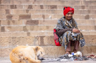 Varanasi, Uttar Pradesh, Hindistan - 20 Ocak 2024: Varanasi 'deki çetelerin yakınındaki ghatlarda oturan geleneksel bir sadhu baba resmi. Sadhu, Kaşhi 'de Ganga yakınlarında ayinler düzenler..