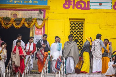 Varanasi, Uttar Pradesh, Hindistan - 20 Ocak 2024: Gurukul 'un kimliği belirsiz genç öğrencileri veya Varanasi' de kış sabahı kutsal nehir gangası yakınlarındaki Kedar Tapınağı 'nda duran bir grup öğrenci.