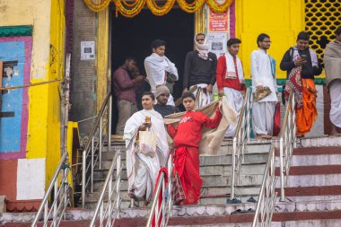 Varanasi, Uttar Pradesh, Hindistan - 20 Ocak 2024: Gurukul 'un kimliği belirsiz genç öğrencileri veya Varanasi' de kış sabahı kutsal nehir gangası yakınlarındaki Kedar Tapınağı 'nda duran bir grup öğrenci.