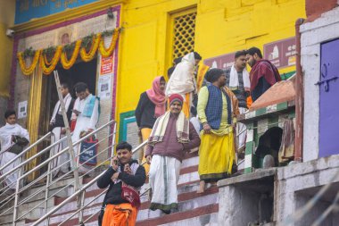 Varanasi, Uttar Pradesh, Hindistan - 20 Ocak 2024: Varanasi 'deki çetelerin yakınında dikilen geleneksel Hint turist portresi. Dünyanın dört bir yanındaki turistler moksha ve Yoga için Varanasi 'yi ziyaret ediyorlar.. 