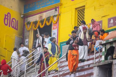 Varanasi, Uttar Pradesh, Hindistan - 20 Ocak 2024: Varanasi 'deki çetelerin yakınında dikilen geleneksel Hint turist portresi. Dünyanın dört bir yanındaki turistler moksha ve Yoga için Varanasi 'yi ziyaret ediyorlar.. 