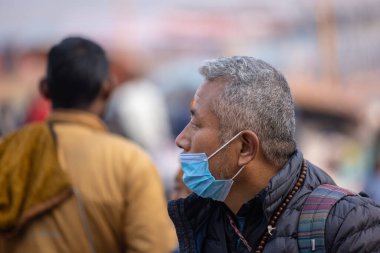 Varanasi, Uttar Pradesh, Hindistan - 20 Ocak 2024: Varanasi 'deki çetelerin yakınında dikilen geleneksel Hint turist portresi. Dünyanın dört bir yanındaki turistler moksha ve Yoga için Varanasi 'yi ziyaret ediyorlar.. 