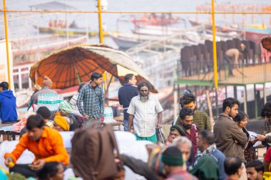 Varanasi, Uttar Pradesh, Hindistan - 20 Ocak 2024: Varanasi 'deki çetelerin yakınında dikilen geleneksel Hint turist portresi. Dünyanın dört bir yanındaki turistler moksha ve Yoga için Varanasi 'yi ziyaret ediyorlar.. 