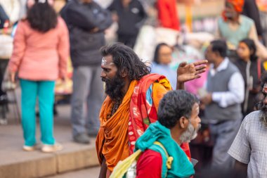 Varanasi, Uttar Pradesh, Hindistan - 20 Ocak 2024: Varanasi 'deki çetelerin yakınında dikilen geleneksel Hint turist portresi. Dünyanın dört bir yanındaki turistler moksha ve Yoga için Varanasi 'yi ziyaret ediyorlar.. 