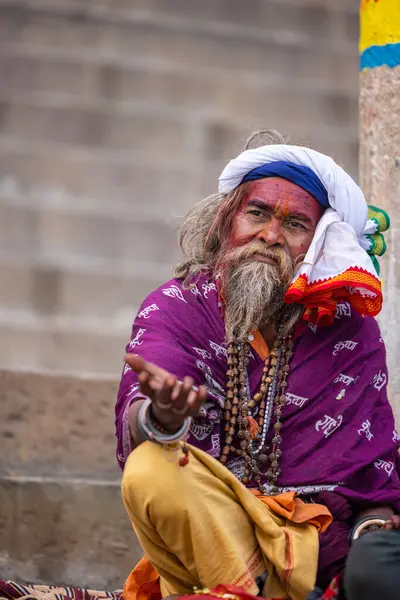 Varanasi, Uttar Pradesh, Hindistan - 20 Ocak 2024: Varanasi 'deki çetelerin yakınındaki ghatlarda oturan geleneksel bir sadhu baba resmi. Sadhu, Kaşhi 'de Ganga yakınlarında ayinler düzenler..