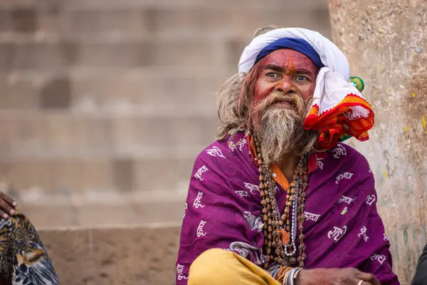 Varanasi, Uttar Pradesh, Hindistan - 20 Ocak 2024: Varanasi 'deki çetelerin yakınındaki ghatlarda oturan geleneksel bir sadhu baba resmi. Sadhu, Kaşhi 'de Ganga yakınlarında ayinler düzenler..