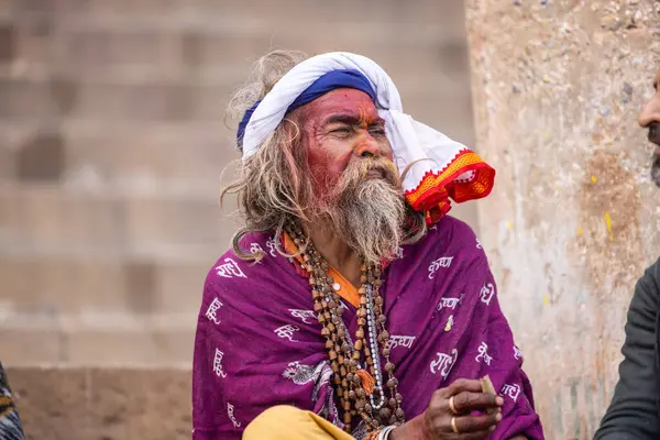Varanasi, Uttar Pradesh, Hindistan - 20 Ocak 2024: Varanasi 'deki çetelerin yakınındaki ghatlarda oturan geleneksel bir sadhu baba resmi. Sadhu, Kaşhi 'de Ganga yakınlarında ayinler düzenler..