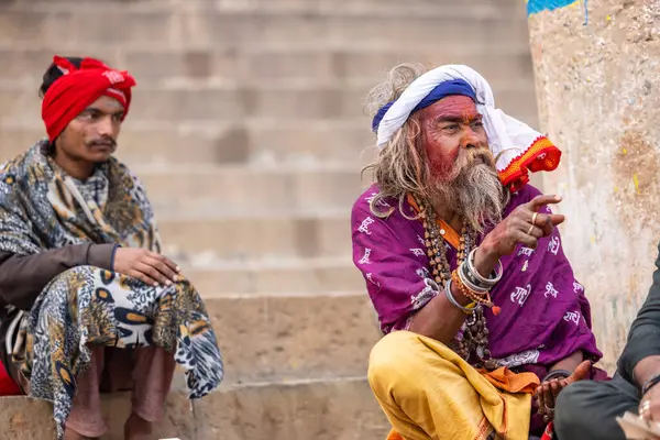 Varanasi, Uttar Pradesh, Hindistan - 20 Ocak 2024: Varanasi 'deki çetelerin yakınındaki ghatlarda oturan geleneksel bir sadhu baba resmi. Sadhu, Kaşhi 'de Ganga yakınlarında ayinler düzenler..