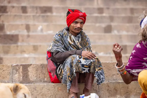 Varanasi, Uttar Pradesh, Hindistan - 20 Ocak 2024: Varanasi 'deki çetelerin yakınındaki ghatlarda oturan geleneksel bir sadhu baba resmi. Sadhu, Kaşhi 'de Ganga yakınlarında ayinler düzenler..