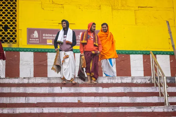 Varanasi, Uttar Pradesh, Hindistan - 20 Ocak 2024: Gurukul 'un kimliği belirsiz genç öğrencileri veya Varanasi' de kış sabahı kutsal nehir gangası yakınlarındaki Kedar Tapınağı 'nda duran bir grup öğrenci.