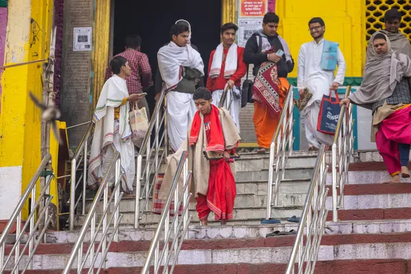 Varanasi, Uttar Pradesh, Hindistan - 20 Ocak 2024: Gurukul 'un kimliği belirsiz genç öğrencileri veya Varanasi' de kış sabahı kutsal nehir gangası yakınlarındaki Kedar Tapınağı 'nda duran bir grup öğrenci.