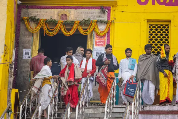 Varanasi, Uttar Pradesh, Hindistan - 20 Ocak 2024: Gurukul 'un kimliği belirsiz genç öğrencileri veya Varanasi' de kış sabahı kutsal nehir gangası yakınlarındaki Kedar Tapınağı 'nda duran bir grup öğrenci.
