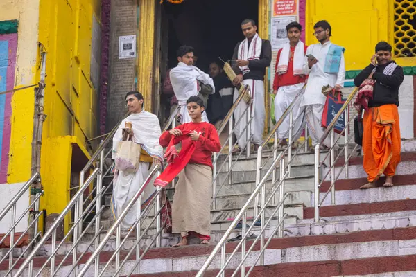 Varanasi, Uttar Pradesh, Hindistan - 20 Ocak 2024: Gurukul 'un kimliği belirsiz genç öğrencileri veya Varanasi' de kış sabahı kutsal nehir gangası yakınlarındaki Kedar Tapınağı 'nda duran bir grup öğrenci.