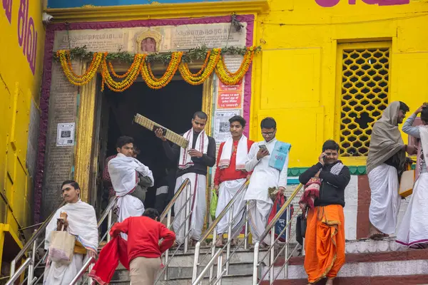 Varanasi, Uttar Pradesh, Hindistan - 20 Ocak 2024: Gurukul 'un kimliği belirsiz genç öğrencileri veya Varanasi' de kış sabahı kutsal nehir gangası yakınlarındaki Kedar Tapınağı 'nda duran bir grup öğrenci.