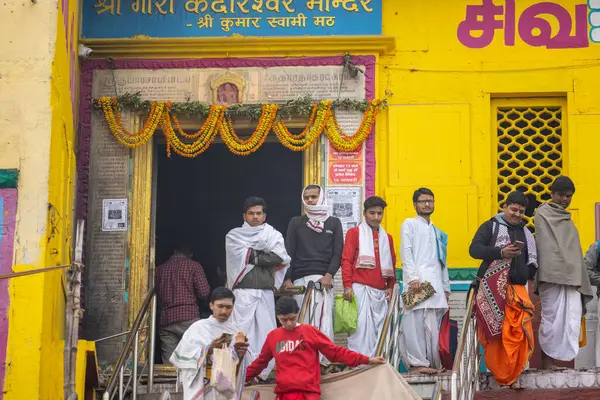Varanasi, Uttar Pradesh, Hindistan - 20 Ocak 2024: Gurukul 'un kimliği belirsiz genç öğrencileri veya Varanasi' de kış sabahı kutsal nehir gangası yakınlarındaki Kedar Tapınağı 'nda duran bir grup öğrenci.