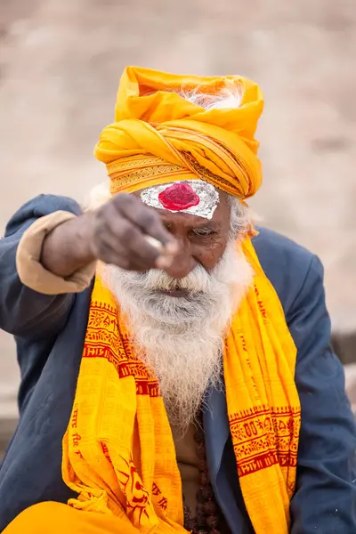 Varanasi, Uttar Pradesh, Hindistan - 20 Ocak 2024: Varanasi 'deki çetelerin yakınındaki ghatlarda oturan geleneksel bir sadhu baba resmi. Sadhu, Kaşhi 'de Ganga yakınlarında ayinler düzenler..