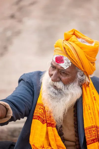 Varanasi, Uttar Pradesh, Hindistan - 20 Ocak 2024: Varanasi 'deki çetelerin yakınındaki ghatlarda oturan geleneksel bir sadhu baba resmi. Sadhu, Kaşhi 'de Ganga yakınlarında ayinler düzenler..