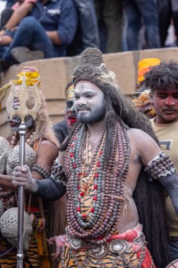 Varanasi, Uttar Pradesh, Hindistan - 20 Mart 2024: Masan Holi, Harishchandra ghat 'ta düzenlenen kutlama sırasında efendi shiva gibi giyinmiş kuru külle boyanmış bir erkek dindar portresi.