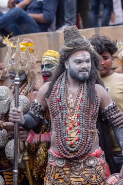 Varanasi, Uttar Pradesh, Hindistan - 20 Mart 2024: Masan Holi, Harishchandra ghat 'ta düzenlenen kutlama sırasında efendi shiva gibi giyinmiş kuru külle boyanmış bir erkek dindar portresi.