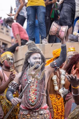 Varanasi, Uttar Pradesh, Hindistan - 20 Mart 2024: Masan Holi, Harishchandra ghat 'ta düzenlenen kutlama sırasında efendi shiva gibi giyinmiş kuru külle boyanmış bir erkek dindar portresi.