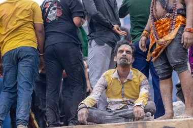 Varanasi, Uttar Pradesh, Hindistan - 20 Mart 2024: Masan Holi, Harishchandra ghat 'ta düzenlenen kutlama sırasında efendi shiva gibi giyinmiş kuru külle boyanmış bir erkek dindar portresi.