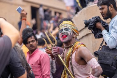 Varanasi, Uttar Pradesh, Hindistan - 20 Mart 2024: Masan Holi, Harishchandra ghat 'ta düzenlenen kutlama sırasında efendi shiva gibi giyinmiş kuru külle boyanmış bir erkek dindar portresi.