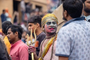 Varanasi, Uttar Pradesh, Hindistan - 20 Mart 2024: Masan Holi, Harishchandra ghat 'ta düzenlenen kutlama sırasında efendi shiva gibi giyinmiş kuru külle boyanmış bir erkek dindar portresi.