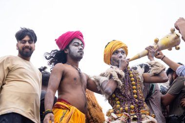 Varanasi, Uttar Pradesh, Hindistan - 20 Mart 2024: Masan Holi, Harishchandra ghat 'ta düzenlenen kutlama sırasında efendi shiva gibi giyinmiş kuru külle boyanmış bir erkek dindar portresi.