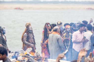 Varanasi, Uttar Pradesh, Hindistan - 20 Mart 2024: Masan Holi, Harishchandra ghat 'ta düzenlenen kutlama sırasında efendi shiva gibi giyinmiş kuru külle boyanmış bir erkek dindar portresi.