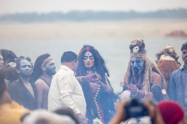 Varanasi, Uttar Pradesh, Hindistan - 20 Mart 2024: Masan Holi, Harishchandra ghat 'ta düzenlenen kutlama sırasında efendi shiva gibi giyinmiş kuru külle boyanmış bir erkek dindar portresi.