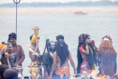 Varanasi, Uttar Pradesh, Hindistan - 20 Mart 2024: Masan Holi, Harishchandra ghat 'ta düzenlenen kutlama sırasında efendi shiva gibi giyinmiş kuru külle boyanmış bir erkek dindar portresi.